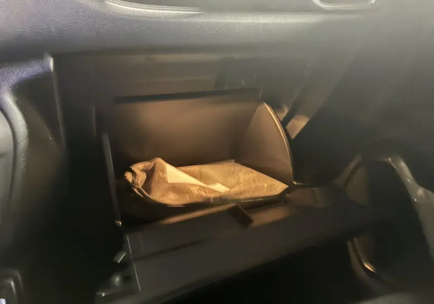 Intérieur du Jeep Renegade 2019 noir, vue sur la boîte à gants ouverte avec un sac beige à l'intérieur.