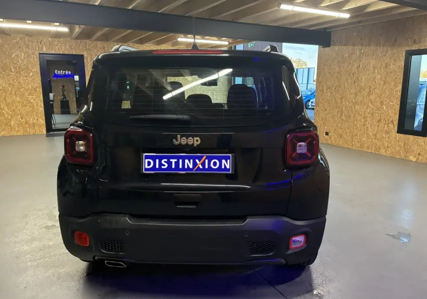 Vue arrière d'un Jeep Renegade noir 2019 en intérieur, avec feux arrière carrés et plaque Distinxion visible.
