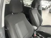 Vue intérieure des sièges avant en tissu gris foncé de la Hyundai i20 2025 noir Phantom Metal avec volant cuir multifonction.