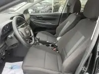 Intérieur de la Hyundai i20 2025 noir Phantom Metal, vue côté conducteur, sièges tissu et volant cuir multifonction.