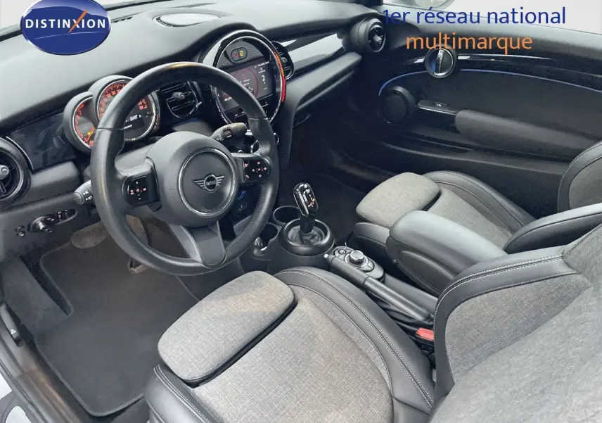 Intérieur de la MINI Cabriolet F57 2023, vue côté conducteur, sièges tissu gris et cuir noir, tableau de bord moderne.