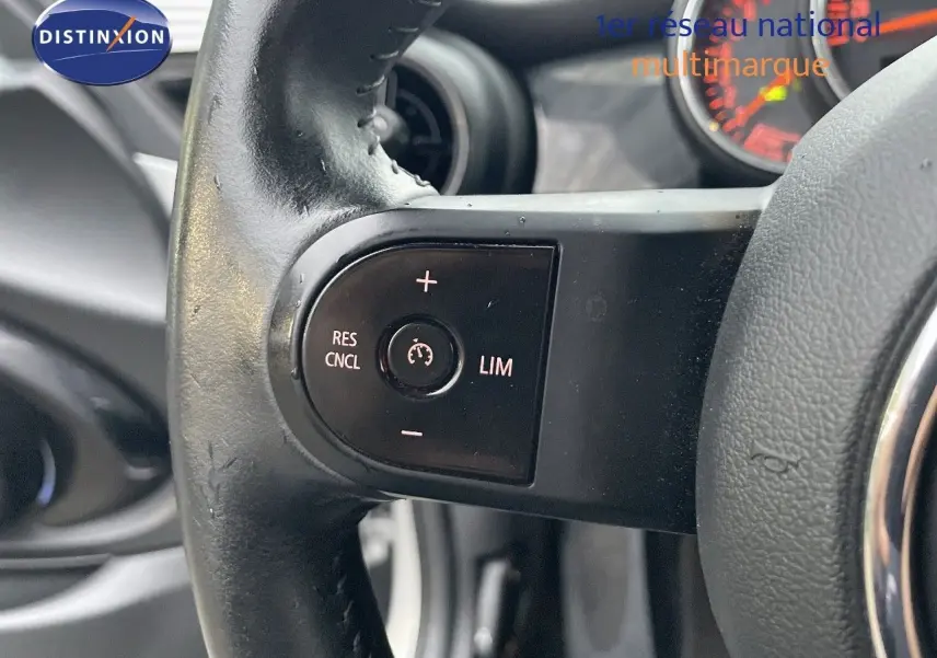 Gros plan sur les commandes de régulateur de vitesse au volant d'une MINI Cabriolet 2023 couleur Melting Silver Metal.