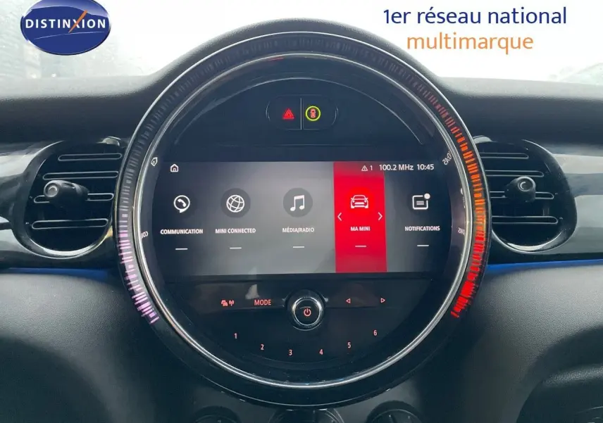 Vue rapprochée du tableau de bord de la MINI Cabriolet F57 2023, écran central rond avec interface multimédia colorée.