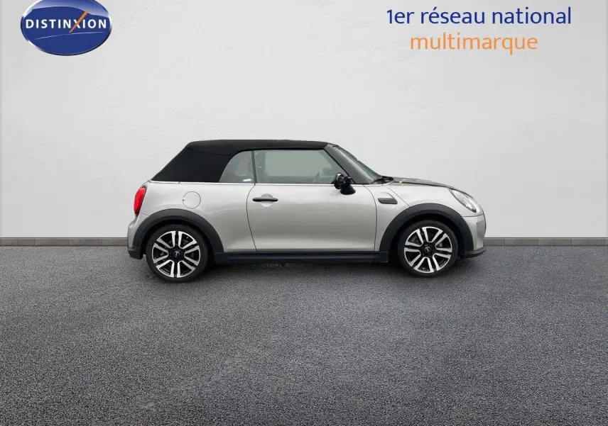 Profil droit d'une MINI Cabriolet 2023 couleur argent métallisé avec toit noir fermé sur fond neutre.