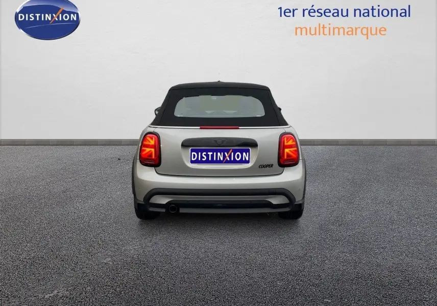 Vue arrière d'une MINI Cabriolet Melting Silver 2023 avec toit noir et feux arrière LED allumés.