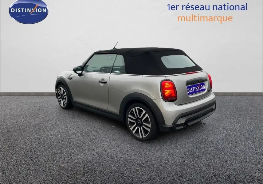 Vue 3/4 arrière droite d'une MINI Cabriolet 2023 couleur Melting Silver Metal avec capote noire fermée.