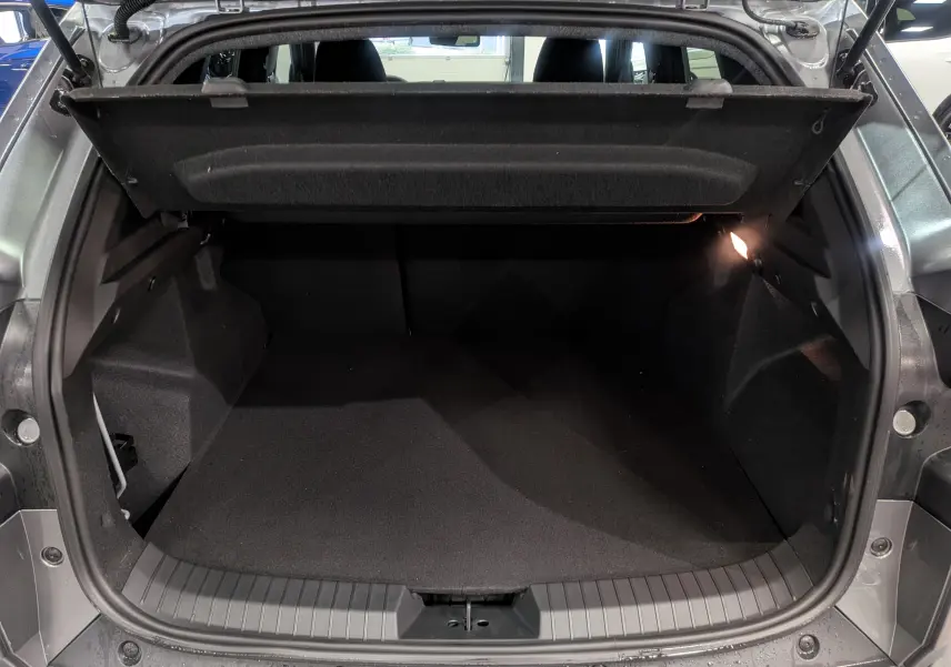 Coffre ouvert vu de l'arrière d'un Dacia Duster gris schiste 2025, montrant un espace de chargement propre et spacieux.