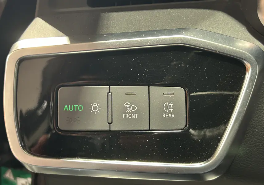 Boutons de commande des phares avant et arrière sur le tableau de bord noir d'une Audi A6 Avant 40 TDI 2019.