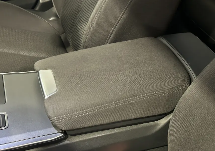 Gros plan sur l'accoudoir central en tissu noir et la console centrale d'une Audi A6 Avant 40 TDI 2019.