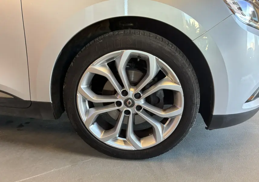 Gros plan sur la roue avant droite gris clair du Renault Grand Scenic 1.5 DCI 110 Business avec jante alliage distinctive.