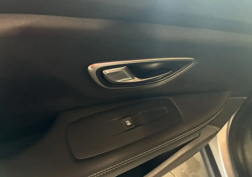 Poignée de porte intérieure côté gauche en cuir noir avec bouton de commande de vitre sur Renault Grand Scenic gris 2017.
