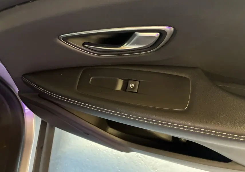 Poignée de porte intérieure côté gauche avec bouton de commande de vitre sur Renault Grand Scenic gris 2017 finition Business.