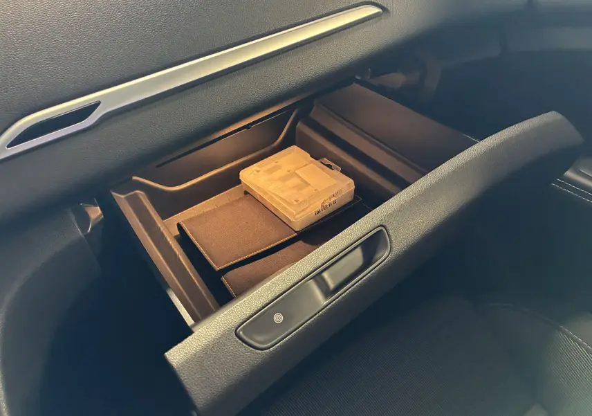 Coffre à gants ouvert côté passager du Renault Grand Scenic gris 2017, montrant un boîtier transparent à l'intérieur.