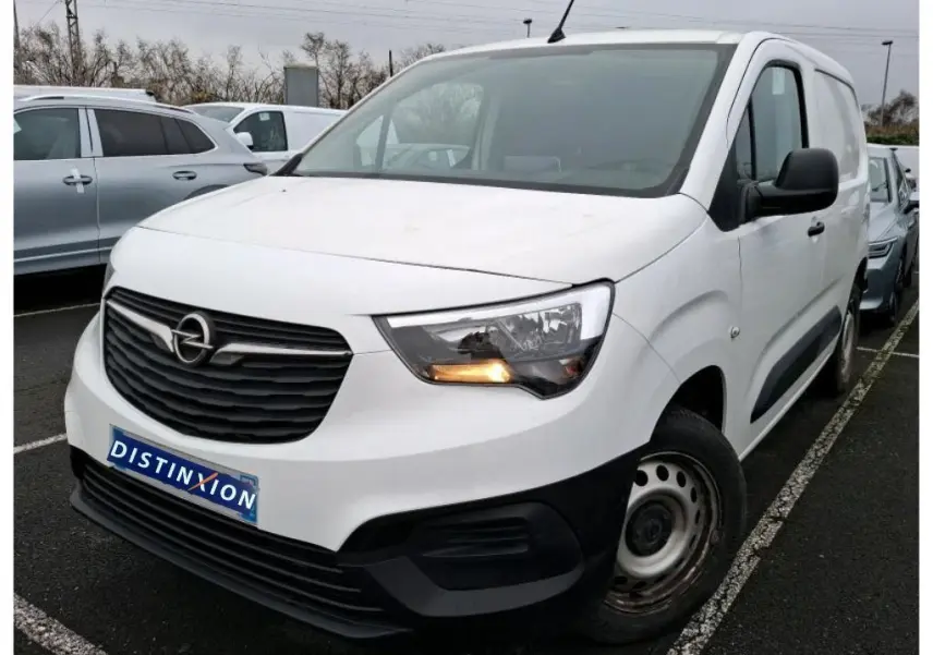 Vue 3/4 avant droit d'un Opel Combo Cargo blanc 2022 avec calandre noire et clignotant avant allumé.
