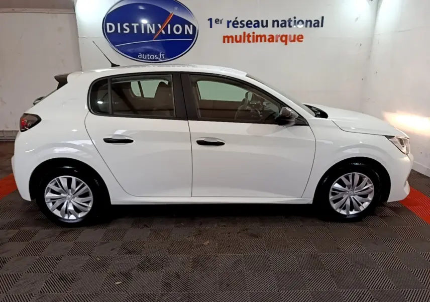 Vue latérale droite d'une Peugeot 208 blanche de 2022, compacte et élégante, en intérieur showroom.