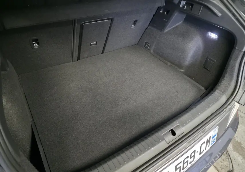Coffre ouvert vu de l'arrière d'une CUPRA Formentor noir, montrant un espace de chargement propre et éclairé.
