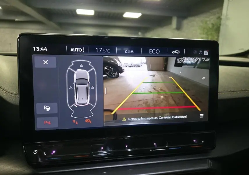 Écran tactile intérieur affichant la caméra de recul et l’aide au stationnement du CUPRA Formentor noir, vue de face.