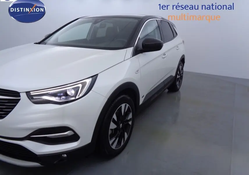 Opel Grandland X blanc nacré vu de 3/4 avant droit, avec jantes noires et toit noir contrastant.