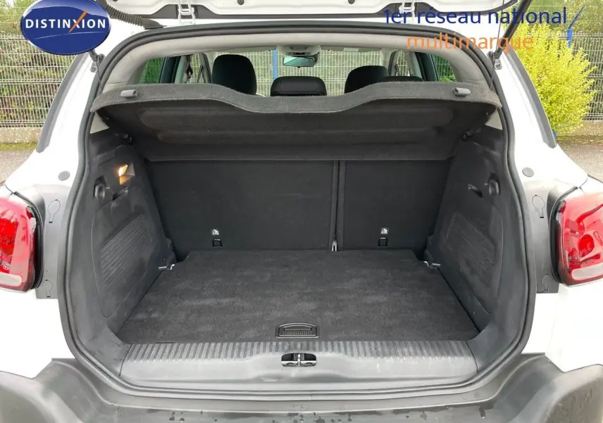 Coffre ouvert vu de l'arrière d'un Citroën C3 Aircross blanc polaire, montrant un espace de chargement propre et spacieux.