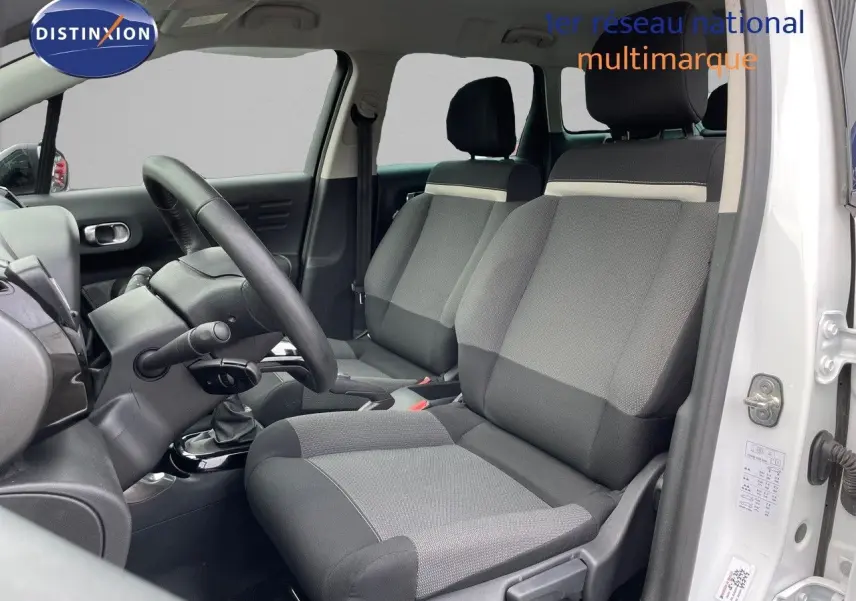 Intérieur du Citroën C3 Aircross blanc polaire 2023, vue côté conducteur sur les sièges tissu gris et noir.