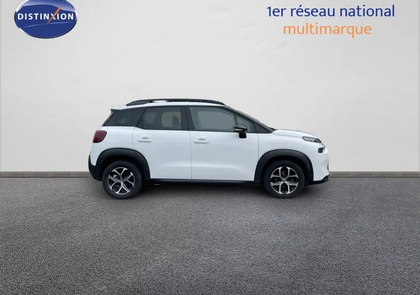 Profil côté gauche d'un Citroën C3 Aircross blanc polaire avec toit noir et jantes alliage bicolores.