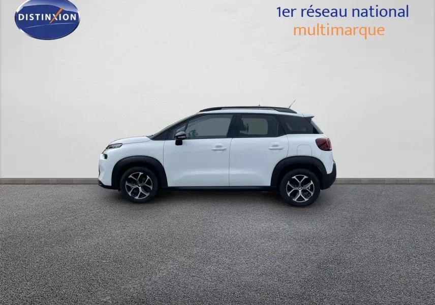 Profil côté gauche d'un Citroën C3 Aircross blanc polaire avec toit noir et jantes alliage bicolores.