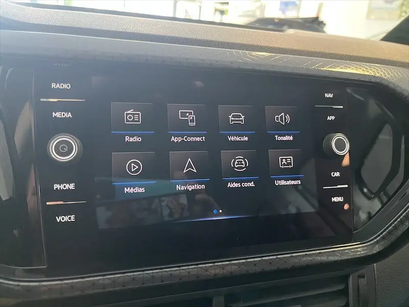 Écran tactile central du Volkswagen T-Cross 1.0 TSI 110 DSG Carat 2021 affichant les menus radio, navigation et aides à la conduite.