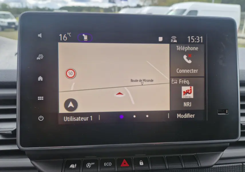 Écran tactile du système de navigation du Renault Trafic Fourgon gris urbain, affichant une carte et options connectivité.