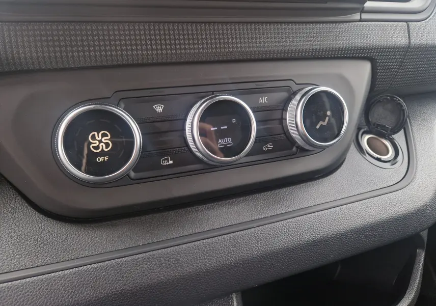 Panneau de commande de climatisation automatique du Renault Trafic Fourgon L1H1 2025 en gris urbain, avec réglages rotatifs.