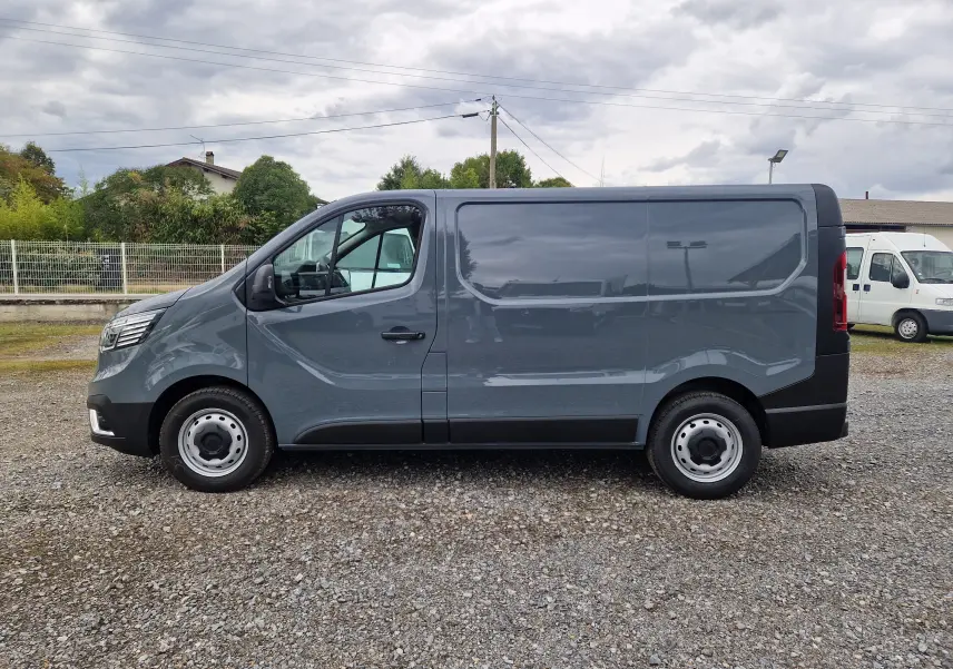 Profil côté gauche d’un Renault Trafic Fourgon gris urbain 2025, avec une carrosserie lisse et des jantes acier simples.