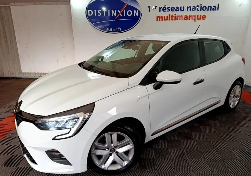Renault Clio Business blanc vue 3/4 avant droit, feux LED allumés, jantes alliage et rétroviseur blanc.