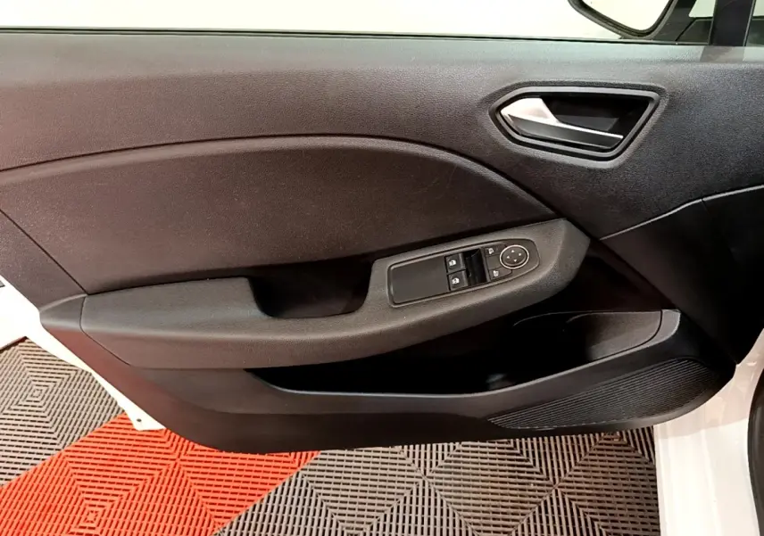 Vue rapprochée de la porte avant gauche noire d'une Renault Clio Business blanche, avec commandes de vitres électriques.