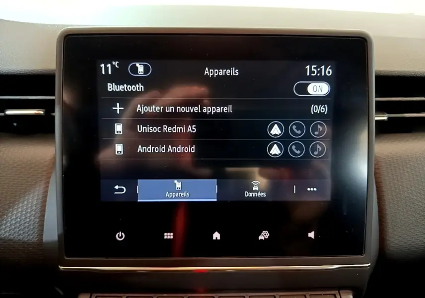 Écran tactile central de la Renault Clio Business blanc, affichant la connexion Bluetooth avec deux appareils listés.