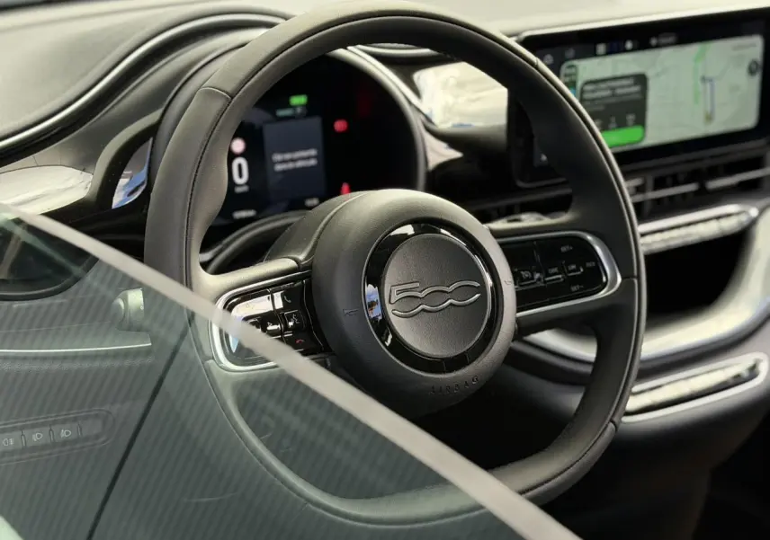 Vue rapprochée du volant noir Soft-Touch du Fiat 500 électrique 2024 avec tableau de bord numérique et écran tactile.