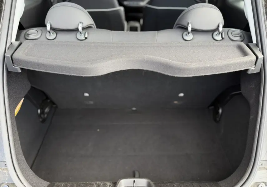 Vue arrière du coffre ouvert d'une FIAT 500 électrique 2024 en Noir Onyx, montrant l'espace de rangement vide.