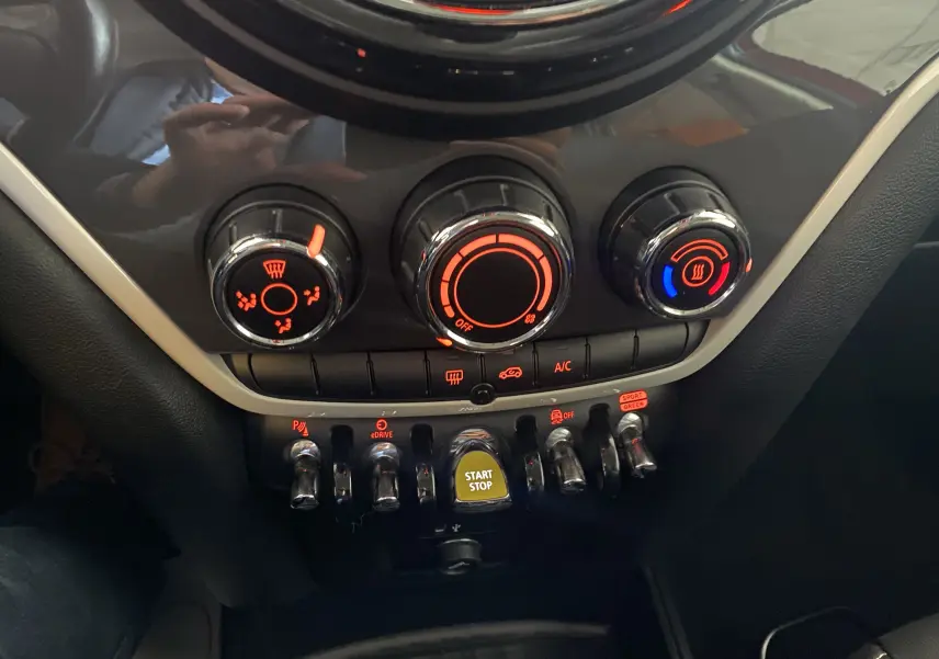 Gros plan sur la console centrale du MINI Countryman rouge toit noir 2018, montrant les commandes climatisation et bouton start/stop.