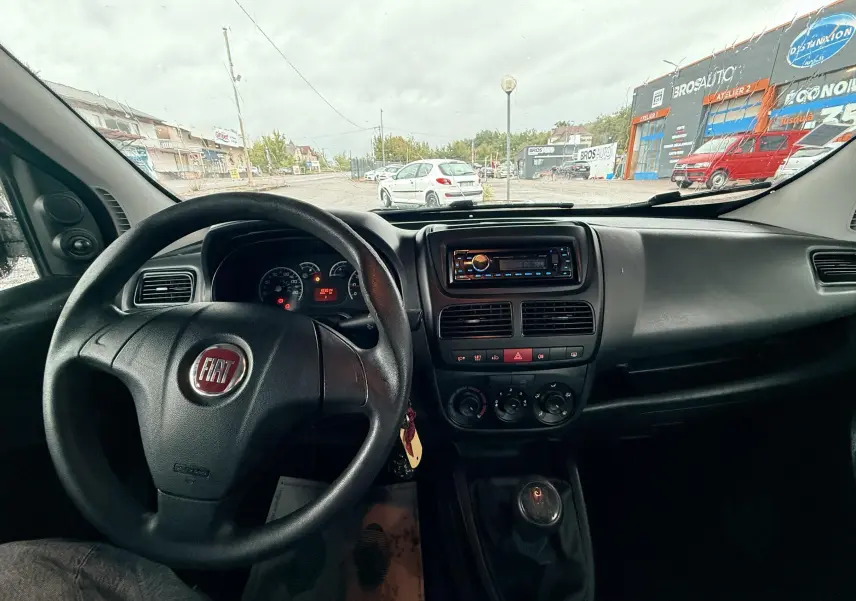 Vue intérieure du tableau de bord et volant du Fiat Doblo Cargo 2011, avec levier de vitesse manuel visible.