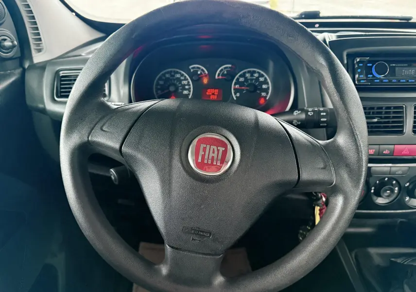 Vue rapprochée du volant noir avec logo FIAT rouge du tableau de bord du Fiat Doblo Cargo 2011.