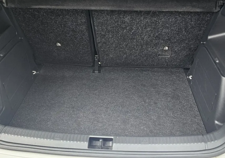 Coffre ouvert vu de face d'une Skoda Fabia 2020 blanc cristal, avec intérieur de coffre noir et tapis propre.