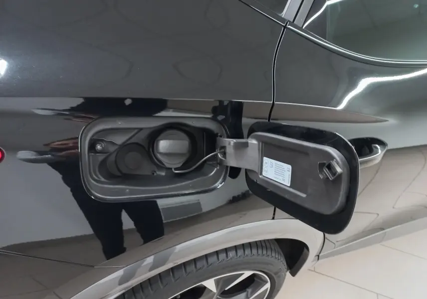 Gros plan sur la trappe à carburant côté gauche d'un CUPRA Formentor Noir Minuit 2023 avec roue et carrosserie visibles.