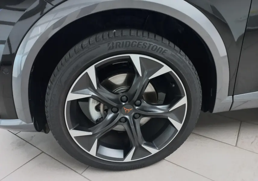 Gros plan sur la roue avant droite du CUPRA Formentor Noir Minuit avec jante alliage noire et argentée au design sportif.