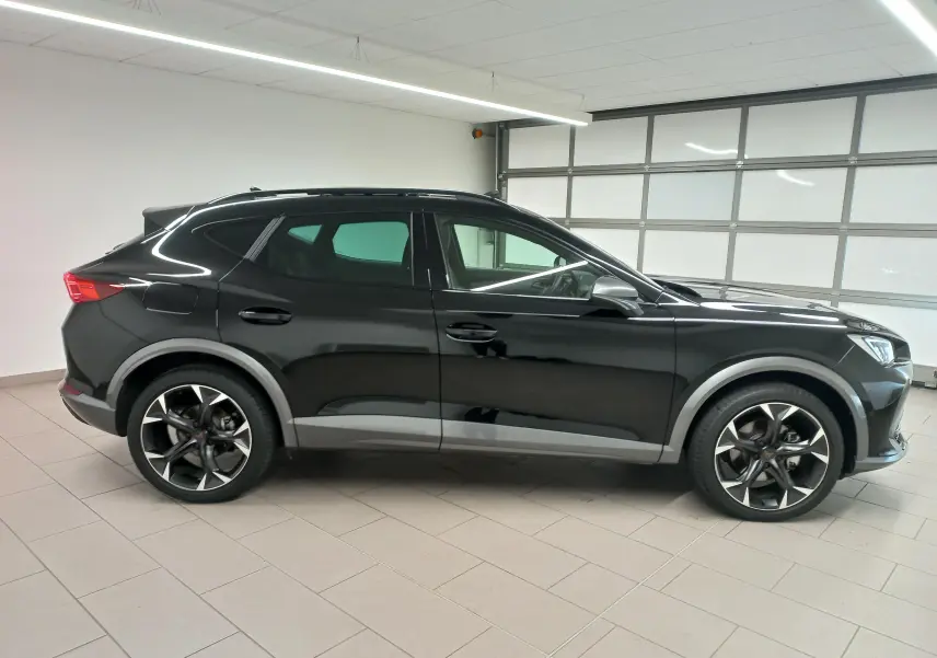 Profil latéral droit du SUV CUPRA Formentor 2023 en noir minuit avec jantes sport et protections grises.