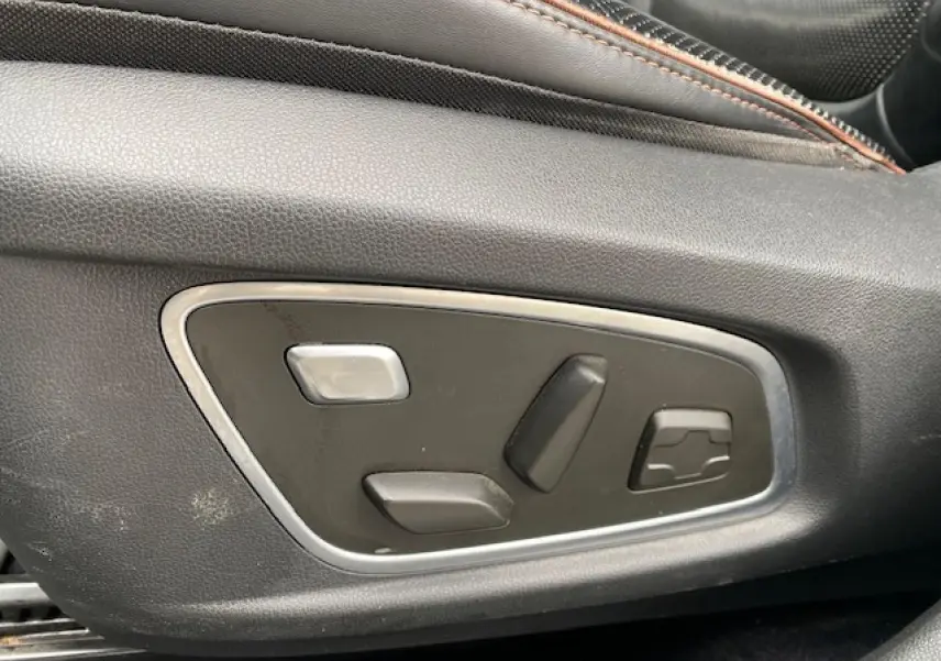 Commandes électriques de réglage du siège conducteur en gros plan dans un Renault Koleos blanc Initiale Paris 2019.