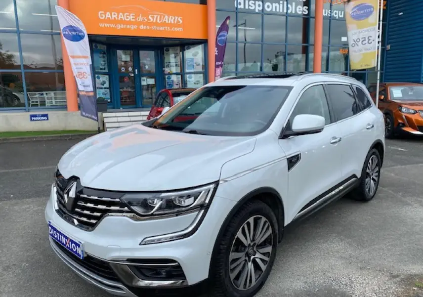 Renault Koleos blanc 2019 en 3/4 avant droit, avec calandre chromée et jantes alliage distinctives.