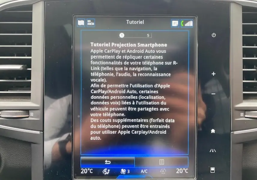 Écran tactile central du Renault Koleos Initiale Paris 2019 affichant un tutoriel sur Apple CarPlay et Android Auto.