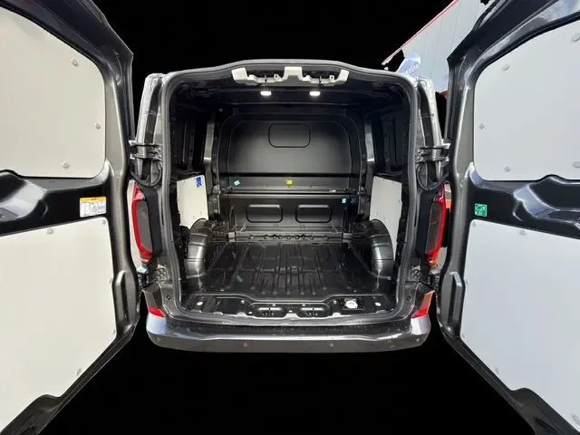 Vue arrière ouverte du Volkswagen Transporter ProCab gris 2026 montrant le compartiment de charge vide avec portes battantes ouvertes.