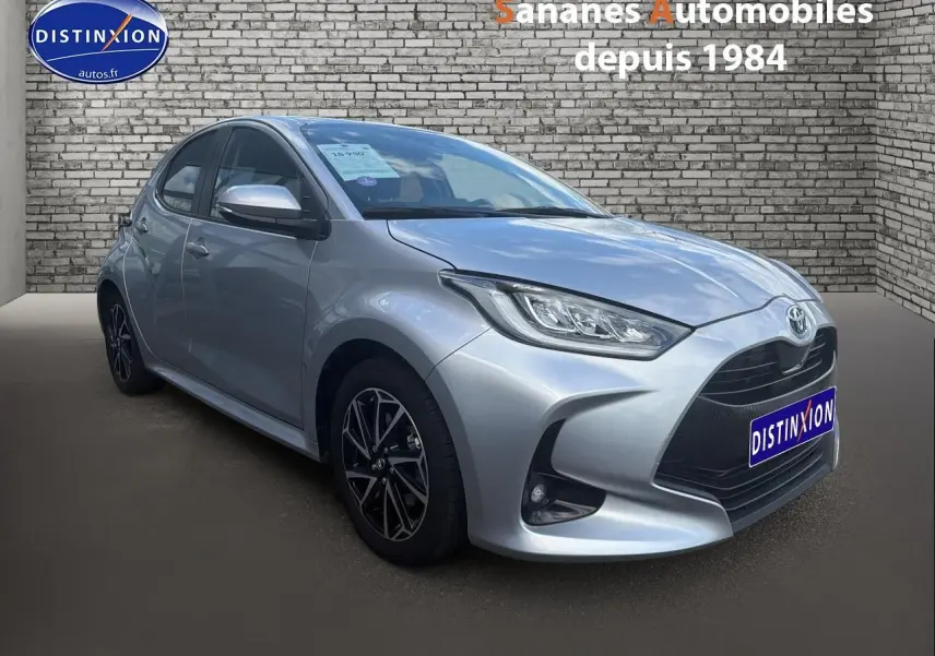 Toyota Yaris Hybrid 2023 gris métallisé en 3/4 avant droit avec jantes alliage bi-ton et vitres surteintées.