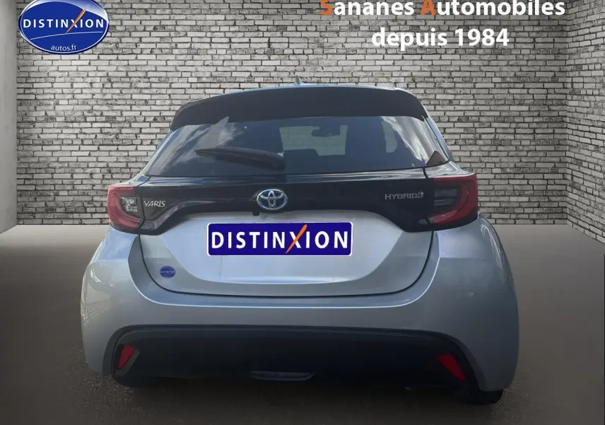 Vue arrière d'une Toyota Yaris Hybrid 116h 2023 en peinture métallisée INC avec toit noir et feux arrière distinctifs.