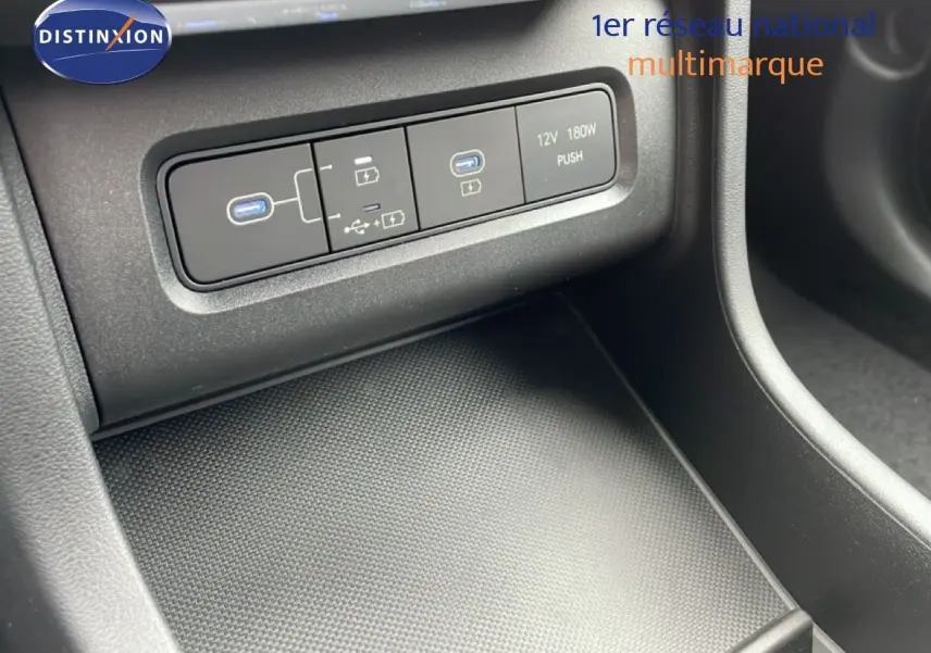 Vue rapprochée de la console centrale du Hyundai Tucson blanc Atlas, montrant les ports USB et prise 12V.