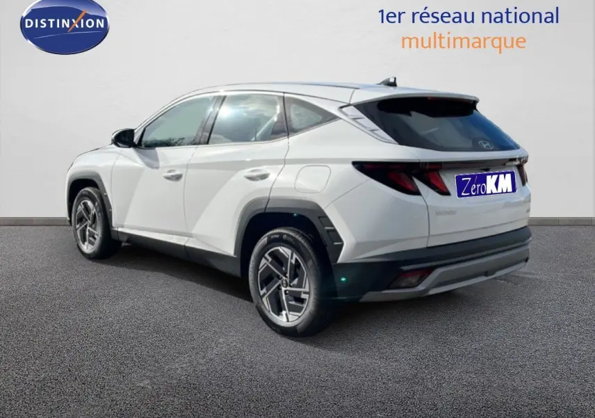 Vue 3/4 arrière droite du Hyundai Tucson blanc Atlas 2026 avec jantes alliage et vitres teintées.